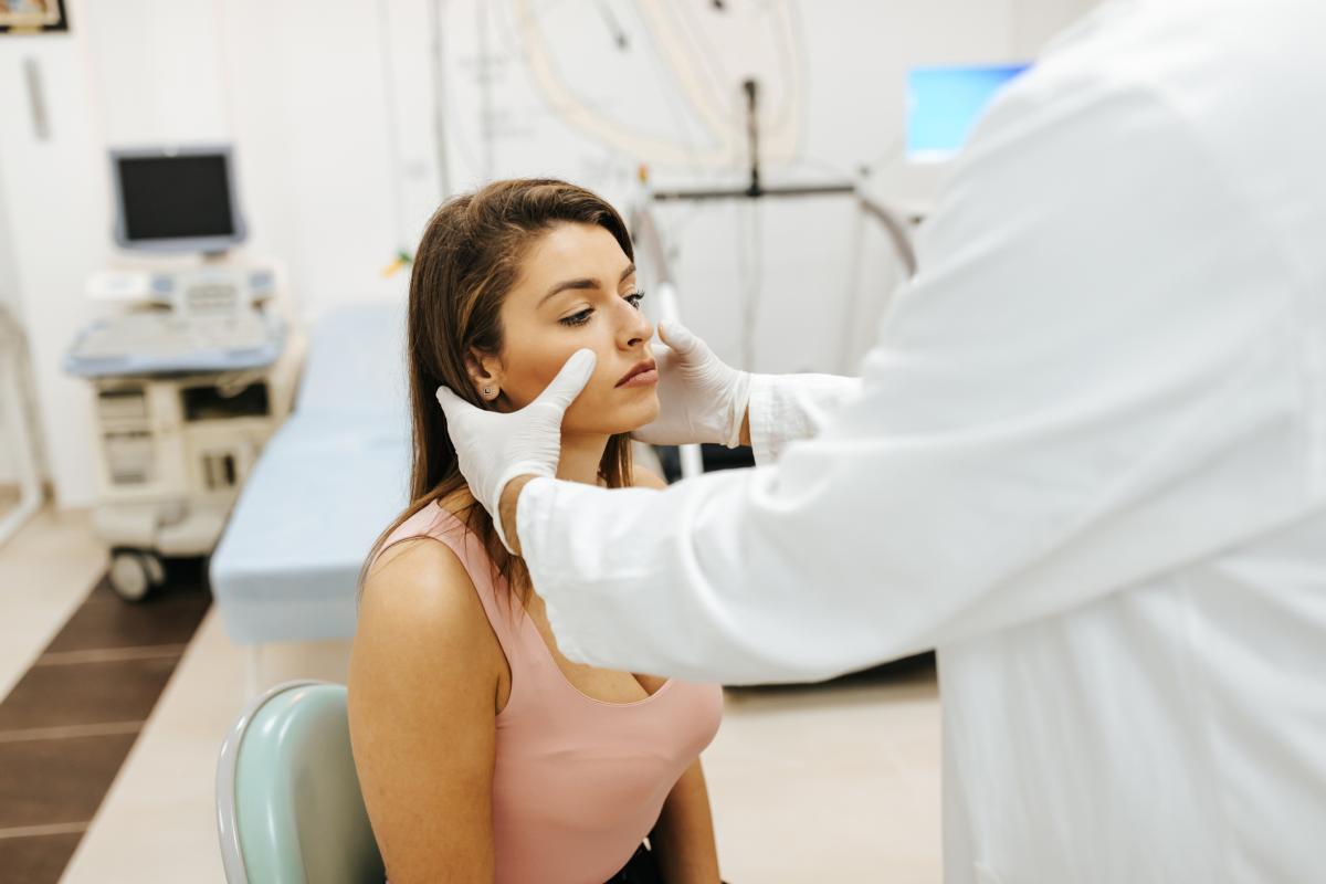 Doctor pressing on woman's sinuses