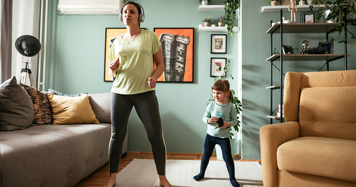 Mom and young daughter doing home workout in living room