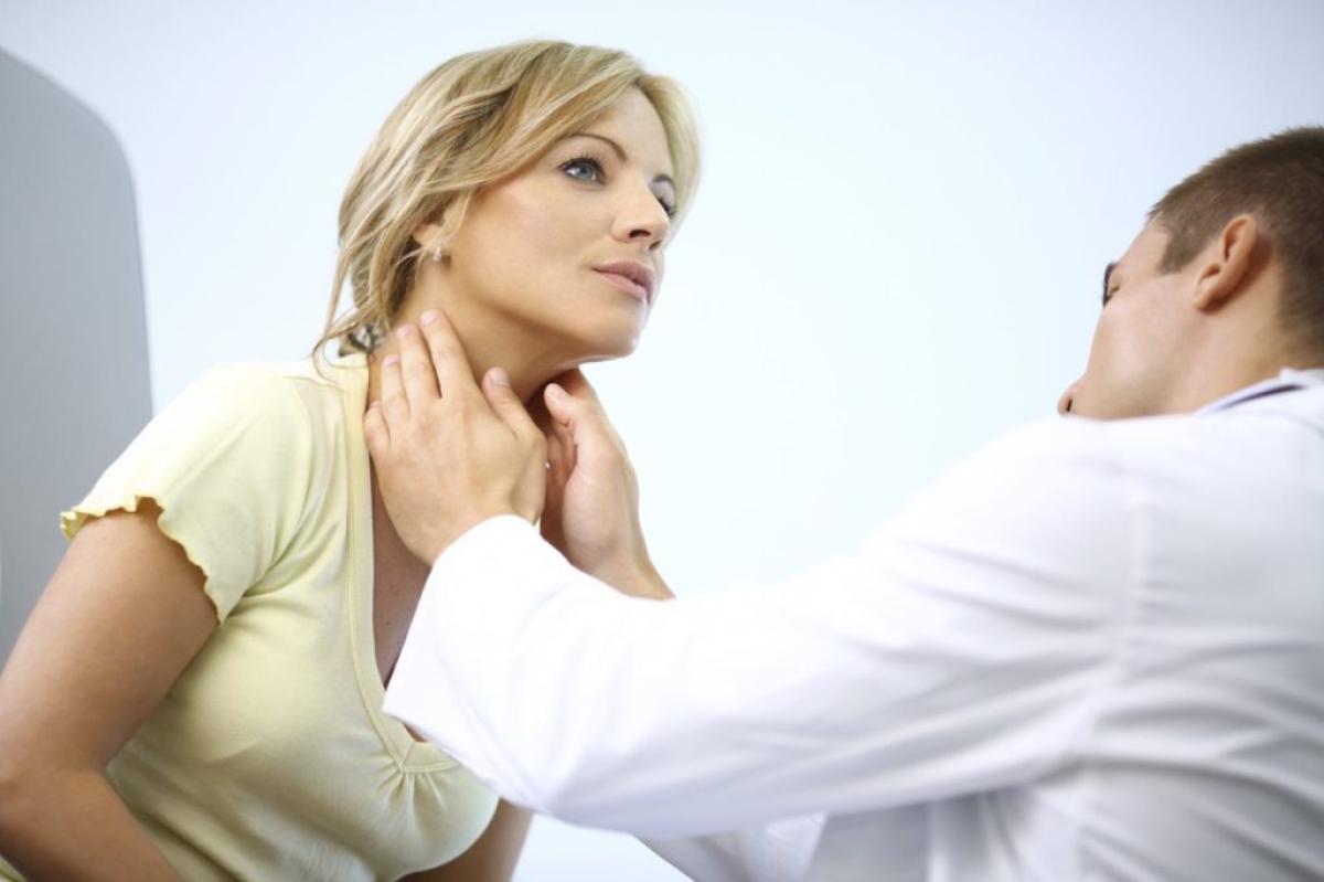 Doctor examining woman's neck