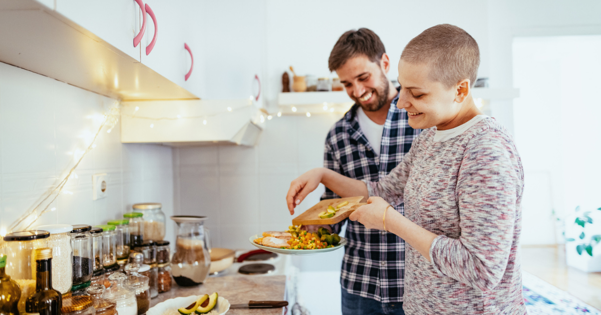 Woman with cancer cooking dinner with her husband