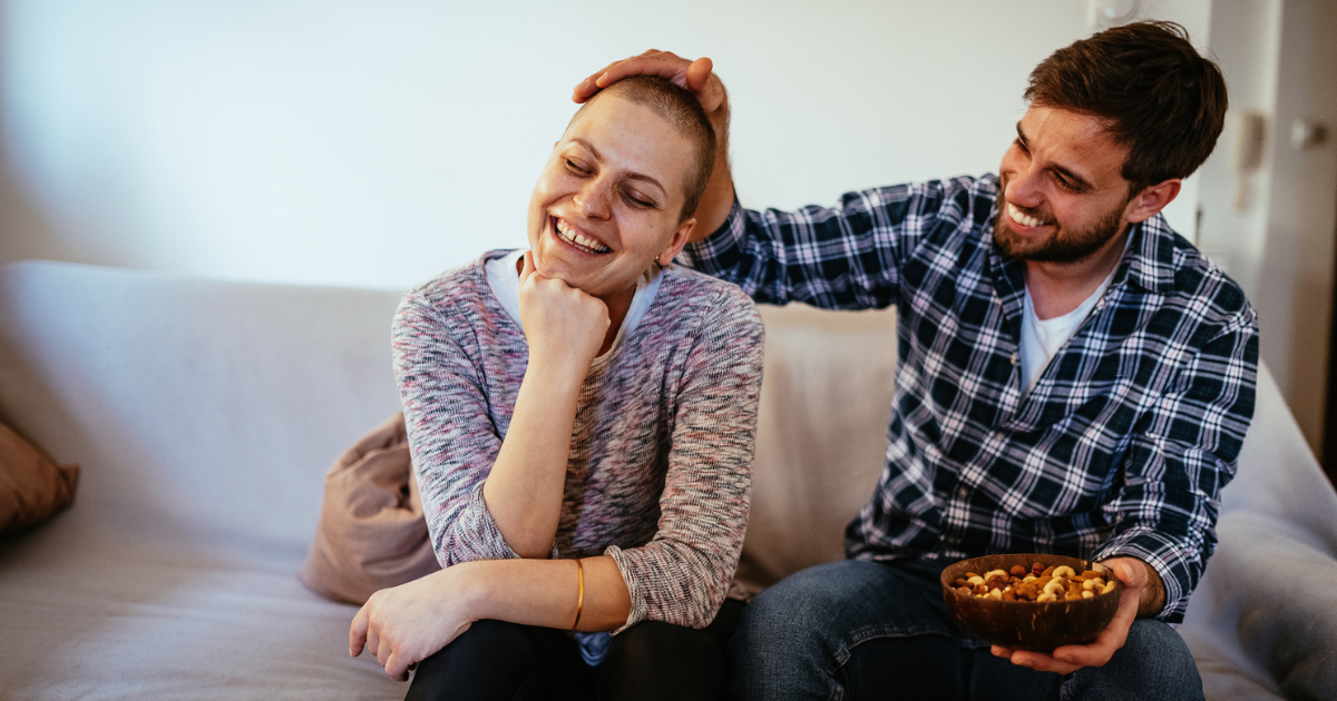 Man and woman with cancer sitting on couch