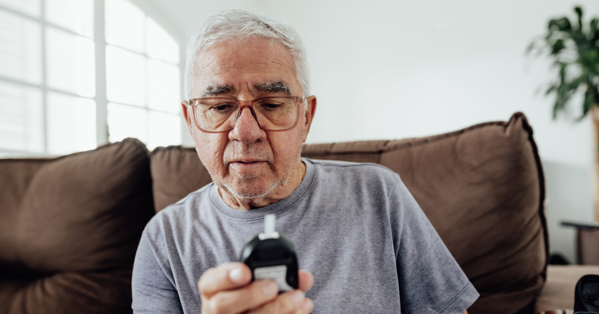 Man looking at glucose meter