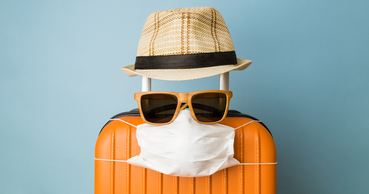 Suitcase with hat, sunglasses, and mask
