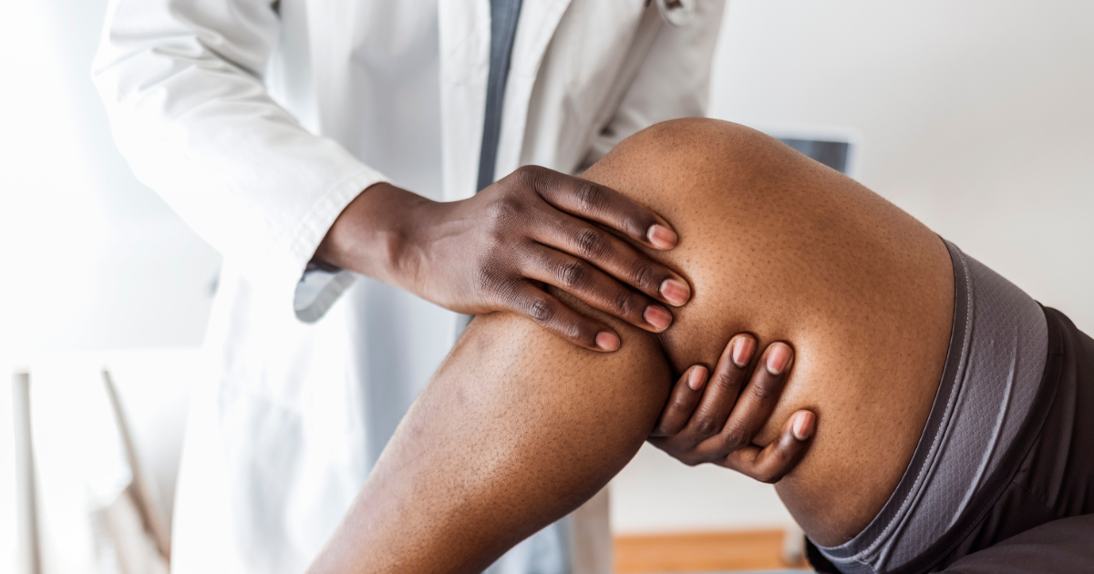 Close up of doctor examining patient's knee