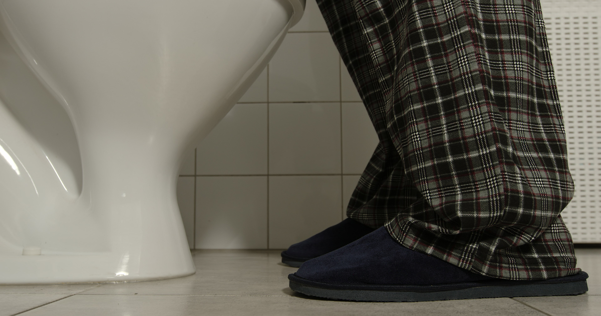 Close up of man wearing slippers using restroom