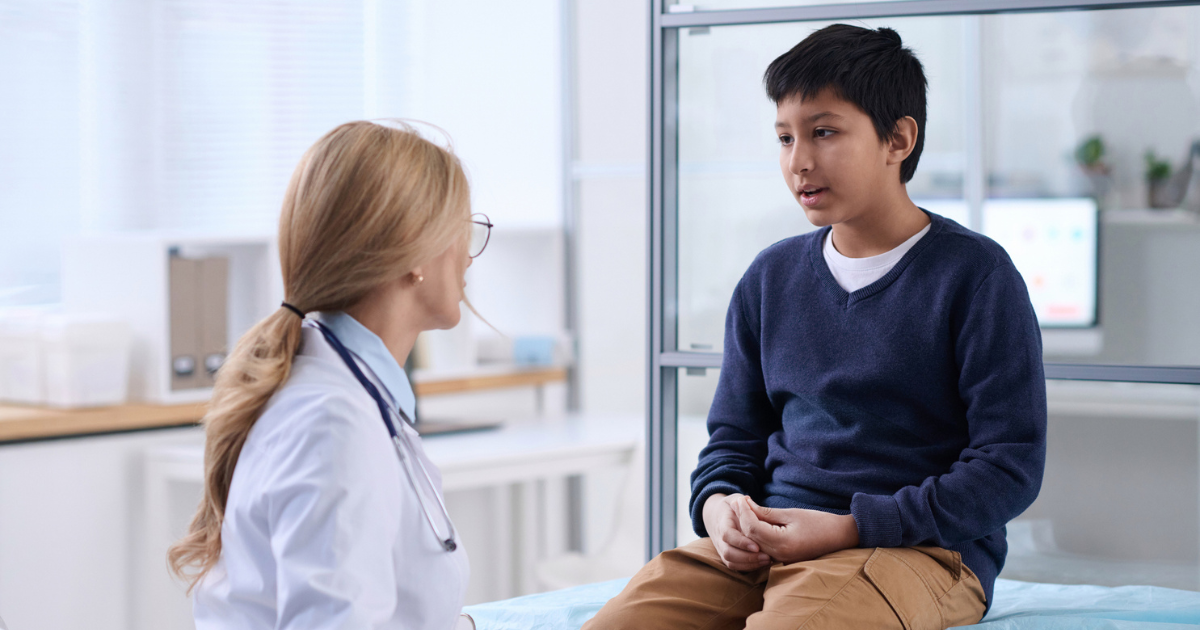 Young boy talking to doctor