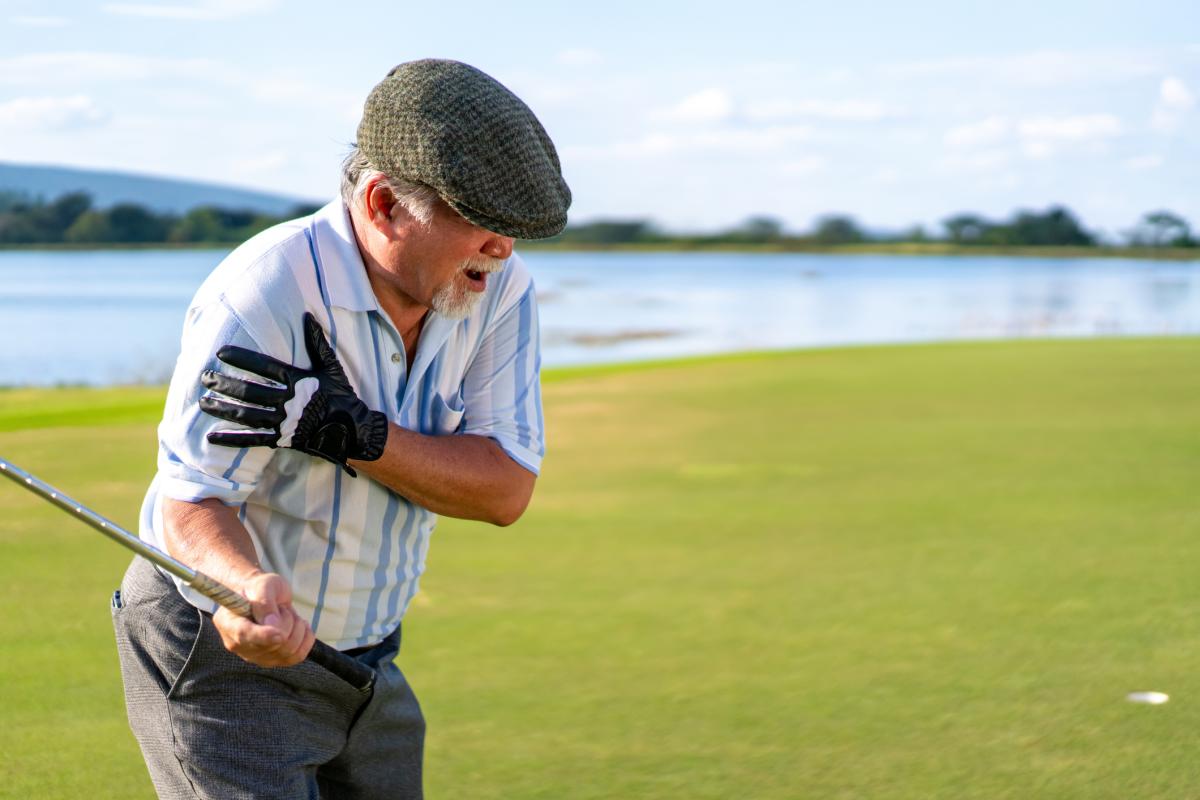 Golfer holding his arm in pain