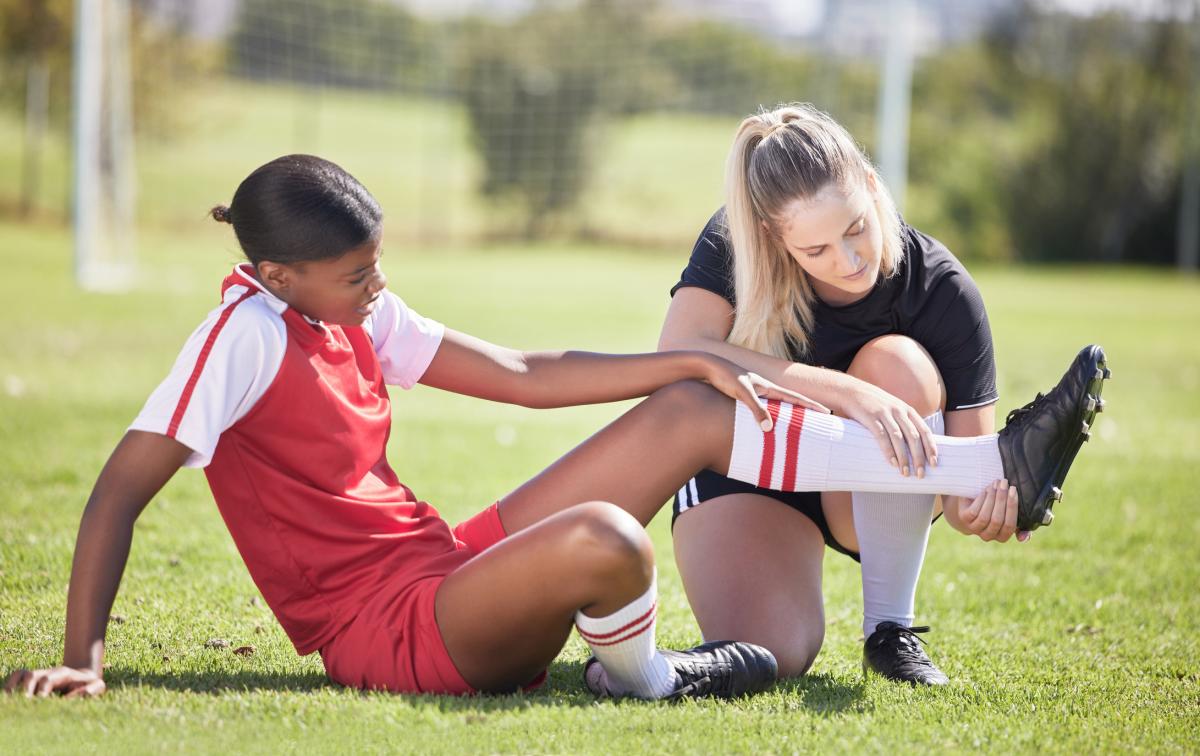 Injured soccer player sitting on field