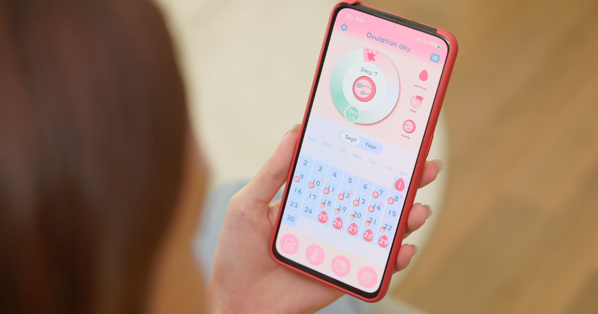 Woman holding phone with period tracking app