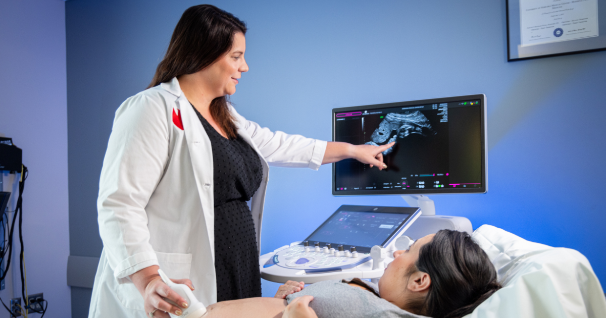 Dr. Rimsza showing an ultrasound image to pregnant woman