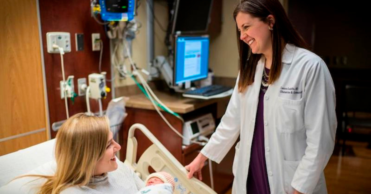 Laura Cudzilo, MD, OB/GYN with patient