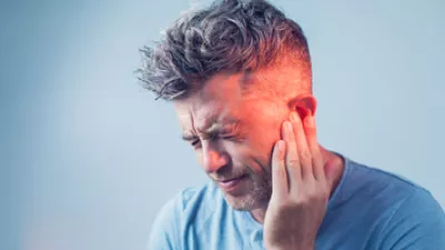 picture of a man holding his ear