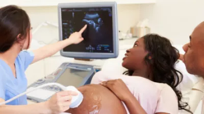 Ultrasound technician performing an ultrasound on a pregnant woman