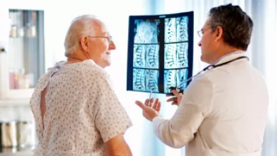 Older man looking at spine x-rays with his doctor