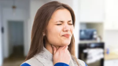Woman grabbing her throat in pain