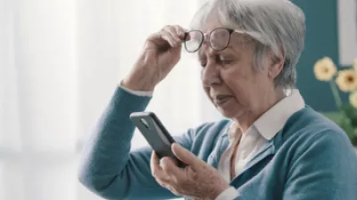 Older woman squinting at her phone