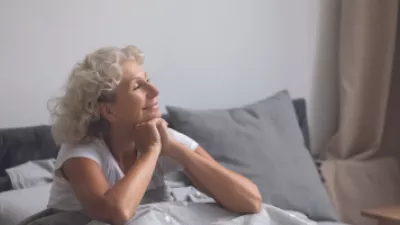 Woman sitting up in bed smiling