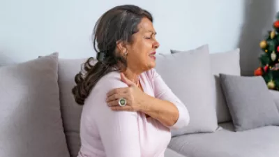 Older woman holding her shoulder in pain