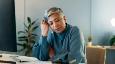 Woman sitting at her desk looking stressed