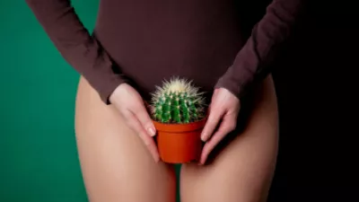 Woman holding cactus in front of her waist