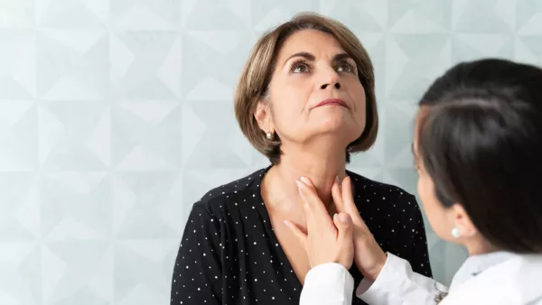 Doctor examining woman's neck