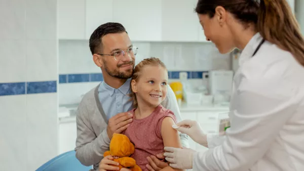 Father and young daughter getting vaccine