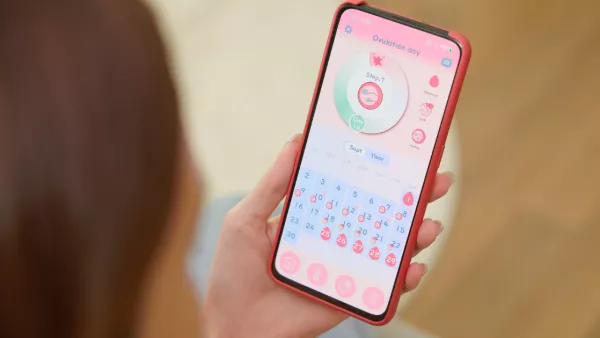 Woman holding phone with period tracking app