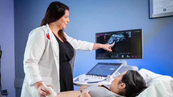 Dr. Rimsza showing an ultrasound image to pregnant woman