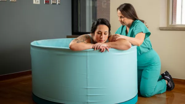 Pregnant woman in water birth tub with NM provider