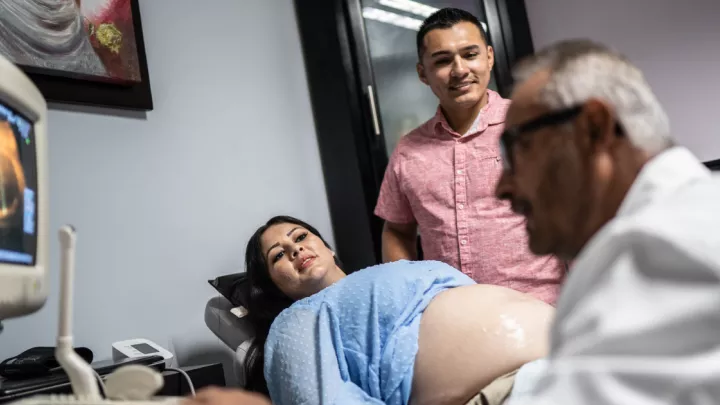 Pregnant woman with husband, getting ultrasound