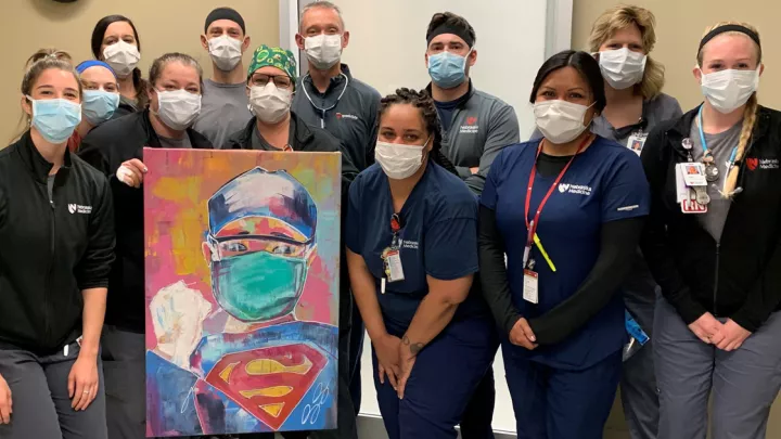 Emergency department poses with Dany Reye's painting