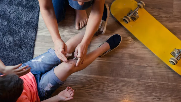 Parent looking at cut on child's leg