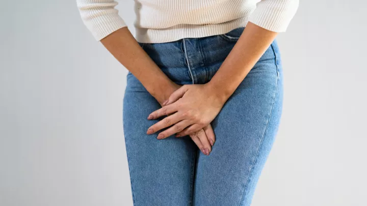 Close up of woman holding her groin