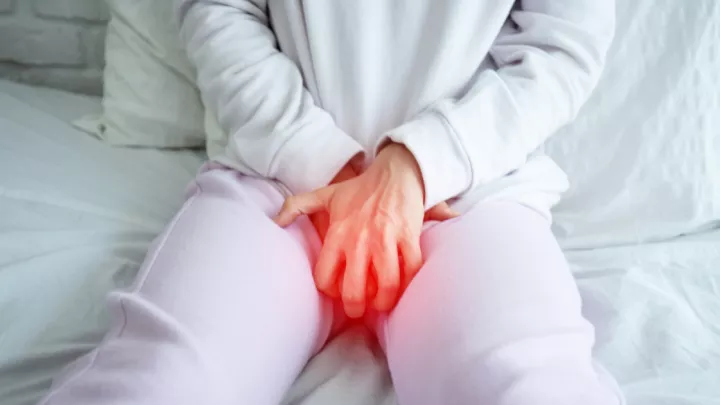 Woman grabbing her groin in pain