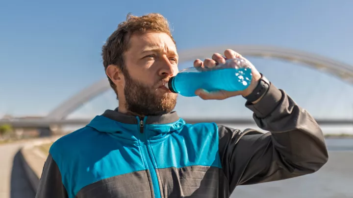 Man drinking a blue sports drink