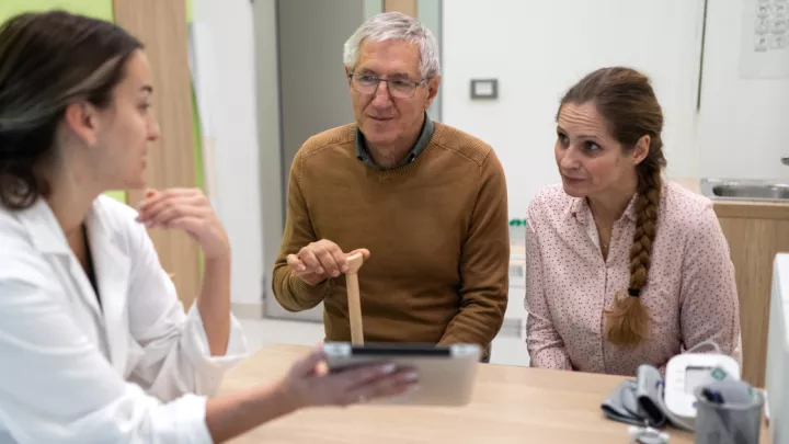 Man and his adult daughter speaking to a doctor