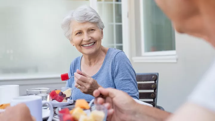 Older woman eating fruit