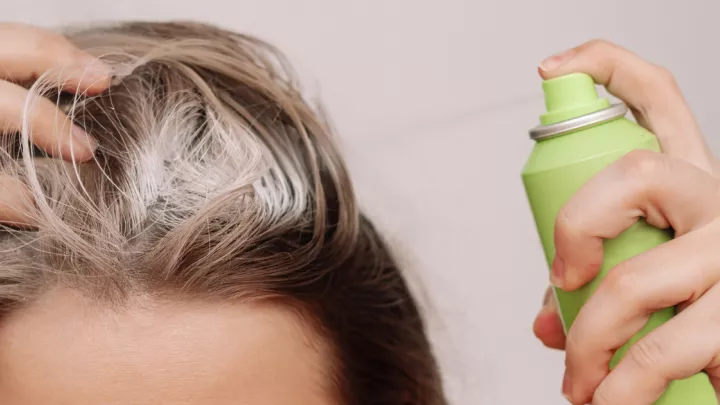 Close up of woman spraying dry shampoo in hair