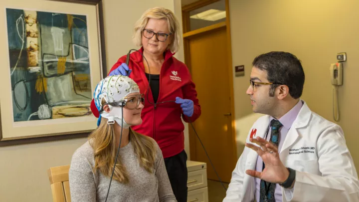 Doctor explaining procedure to patient with a medical cap