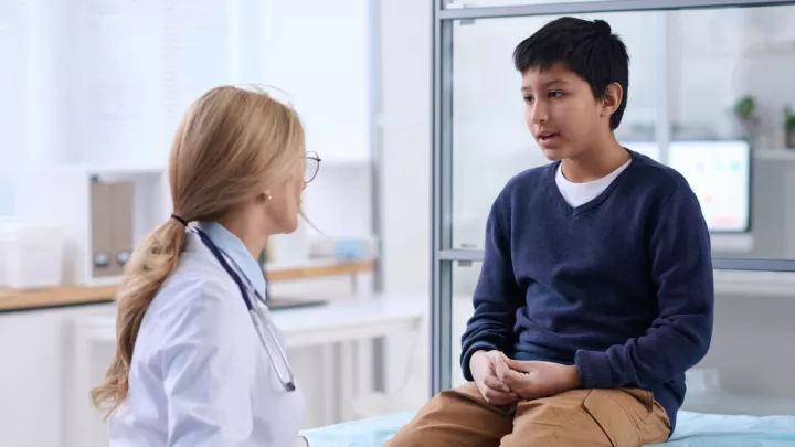 Young boy talking to doctor